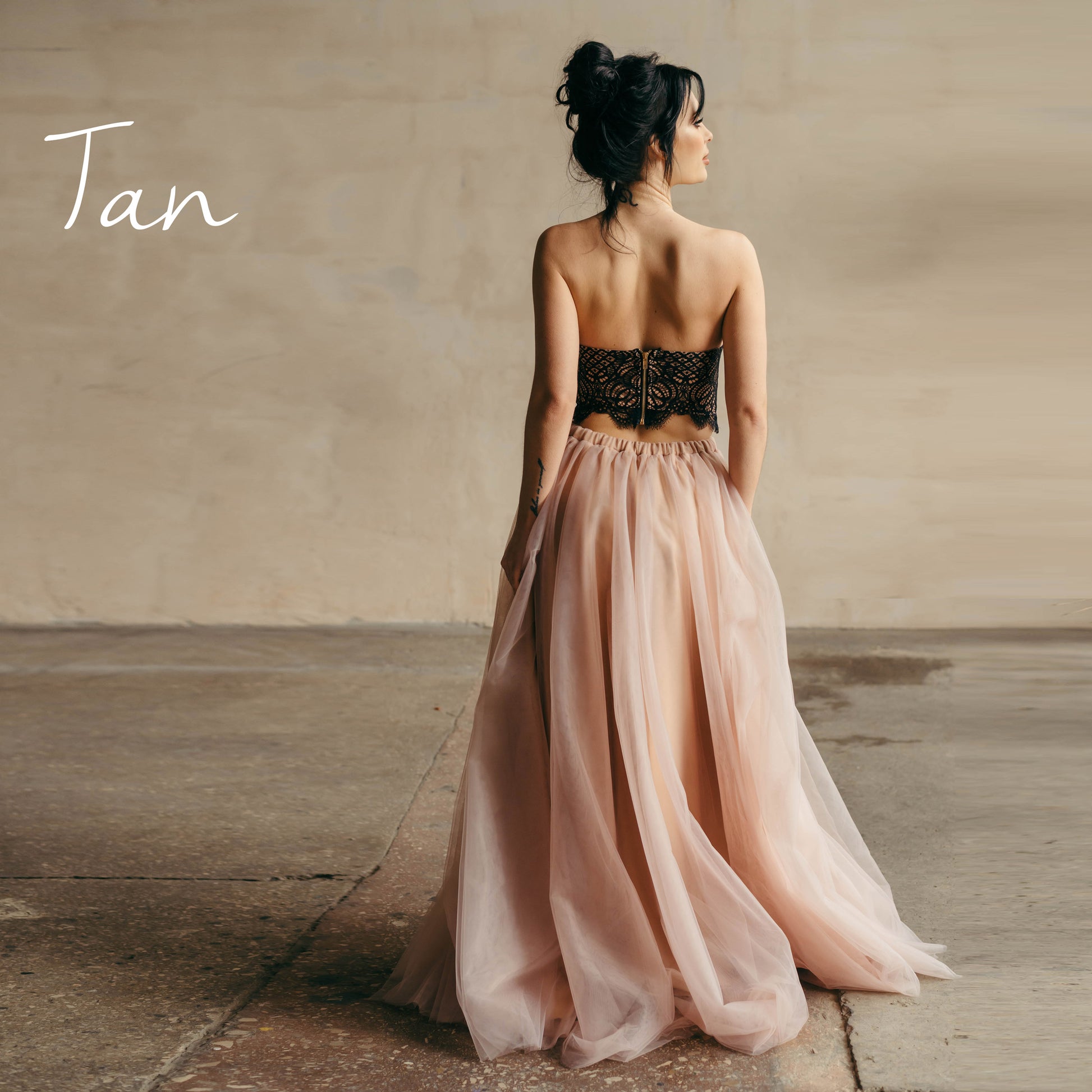 Tan tulle skirt with black top worn at a beach wedding ceremony.