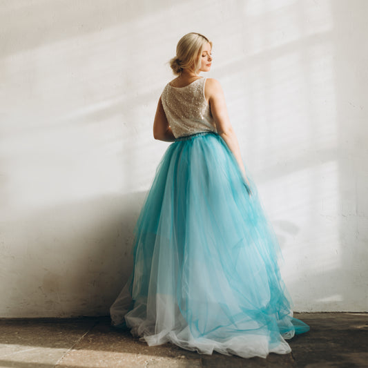 Bride wearing teal and white ombré skirt styled with ivory top for modern wedding.