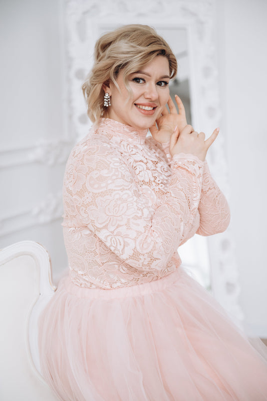 Soft, dreamy close-up of chic plus-size bride in blush lace top and blush tulle skirt—an ethereal and romantic bridal moment.