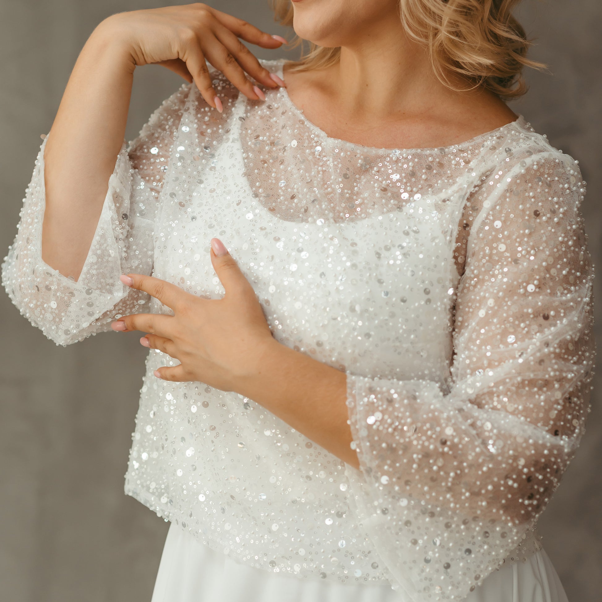 Close-up of neckline and sleeve detail on sequin bridal blouse with pearl embellishment – sparkly wedding separates.