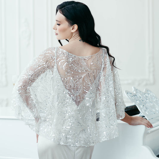 Close-up of back view showing intricate ginkgo-inspired lace and beadwork on bridal cape