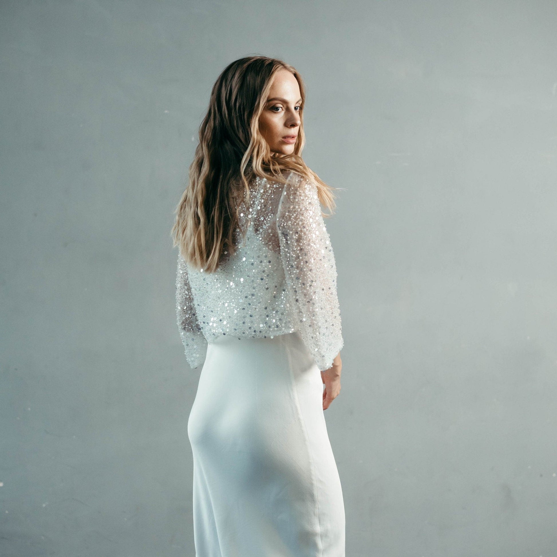 Model wearing bridal trousers with pearl and sequin wedding top – modern two-piece bridal outfit.