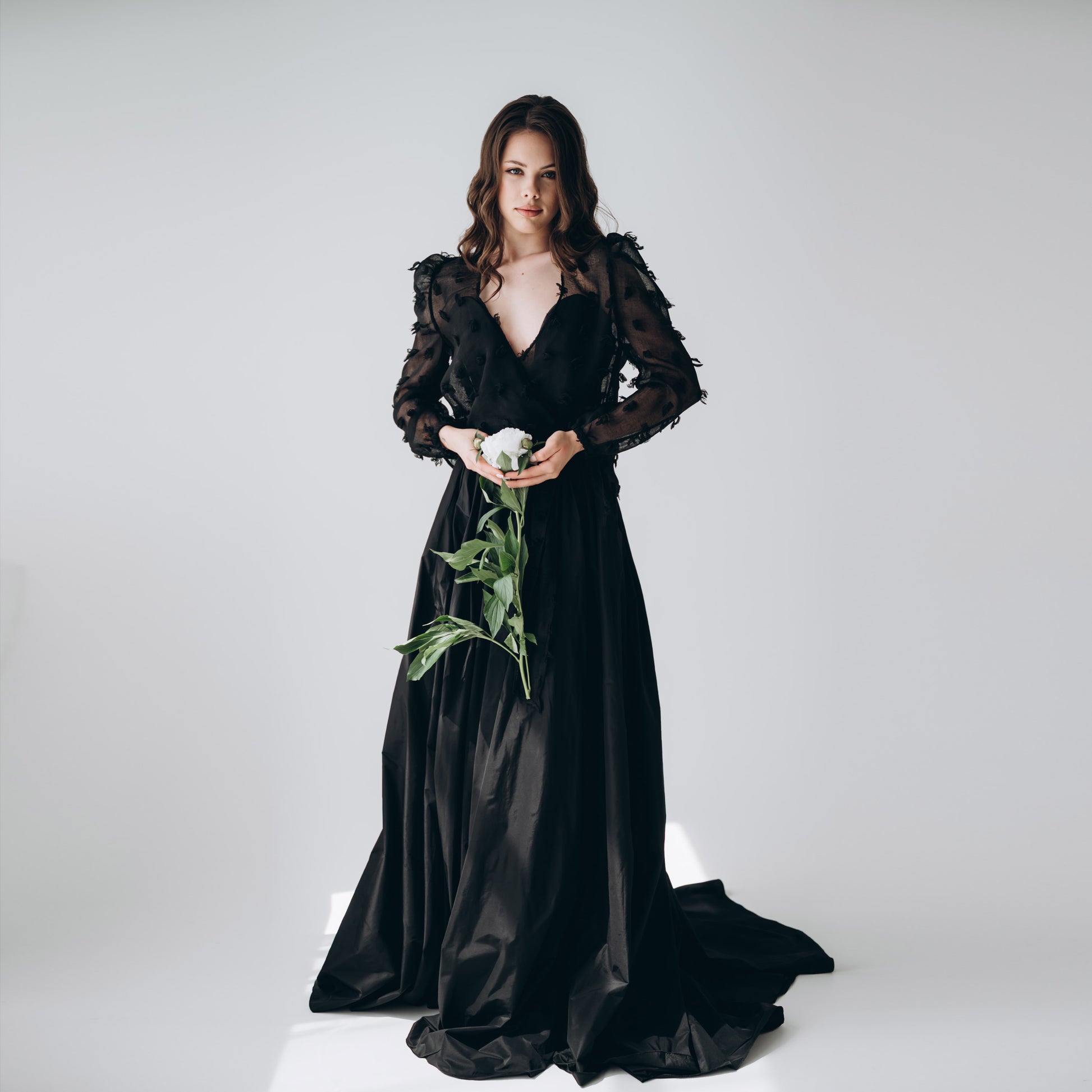 Model wearing black taffeta wedding skirt with train, styled with long-sleeve guipure top