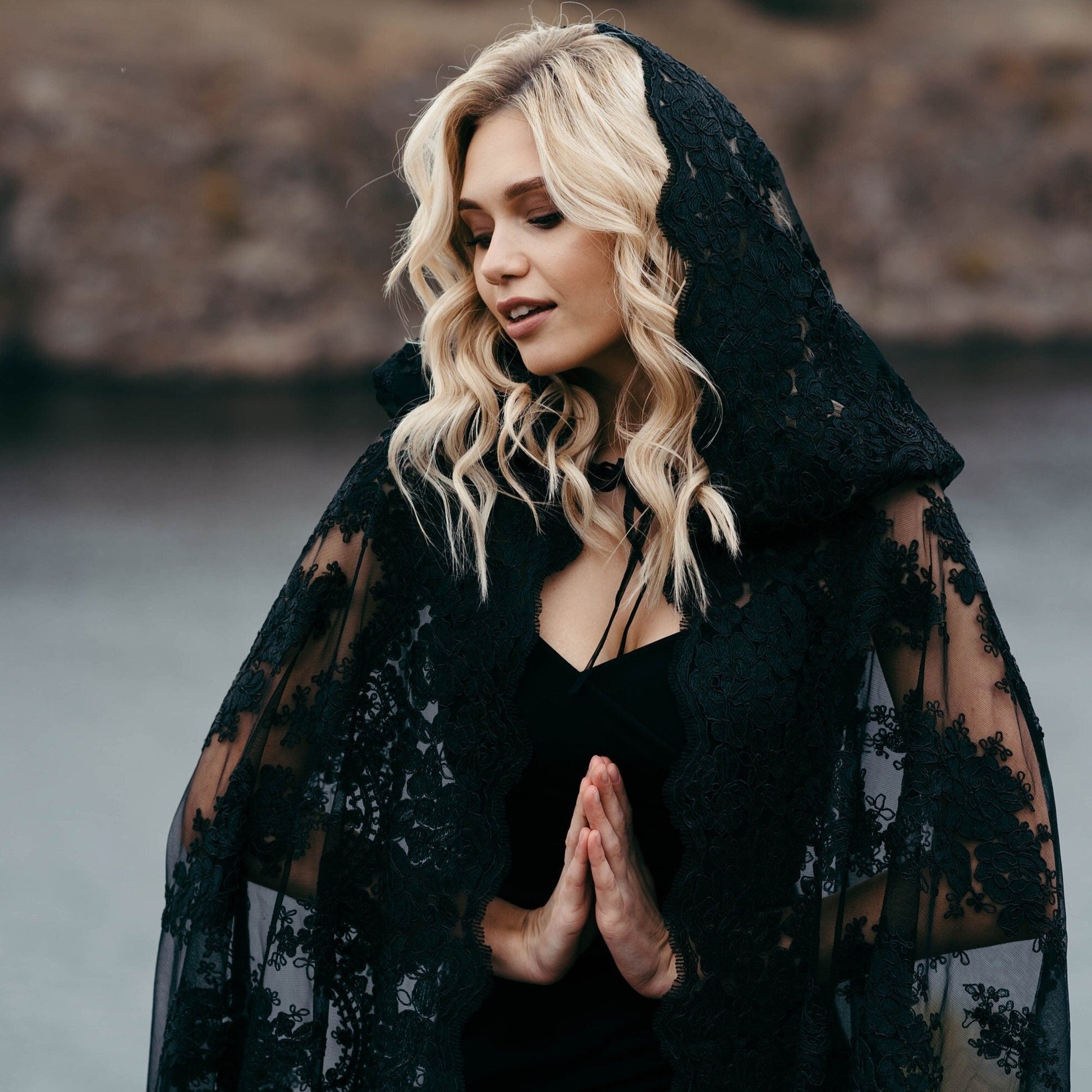 Black lace hooded wedding cape worn on cliffside for gothic bridal shoot