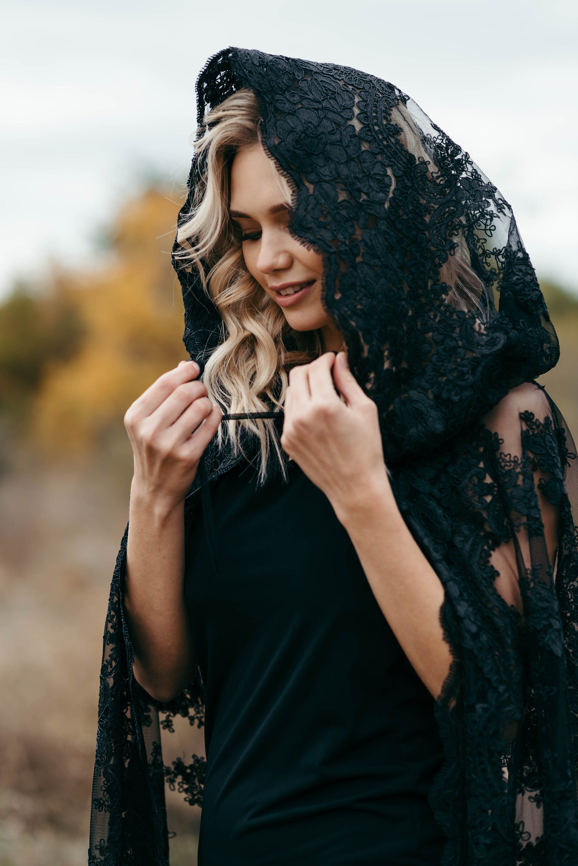 Black lace hooded wedding cloak worn for a gothic bridal shoot