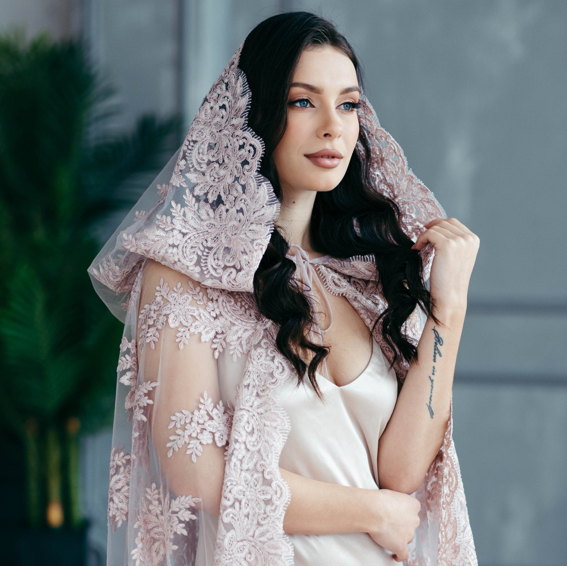 Blush pink lace bridal hooded cape worn over satin gown