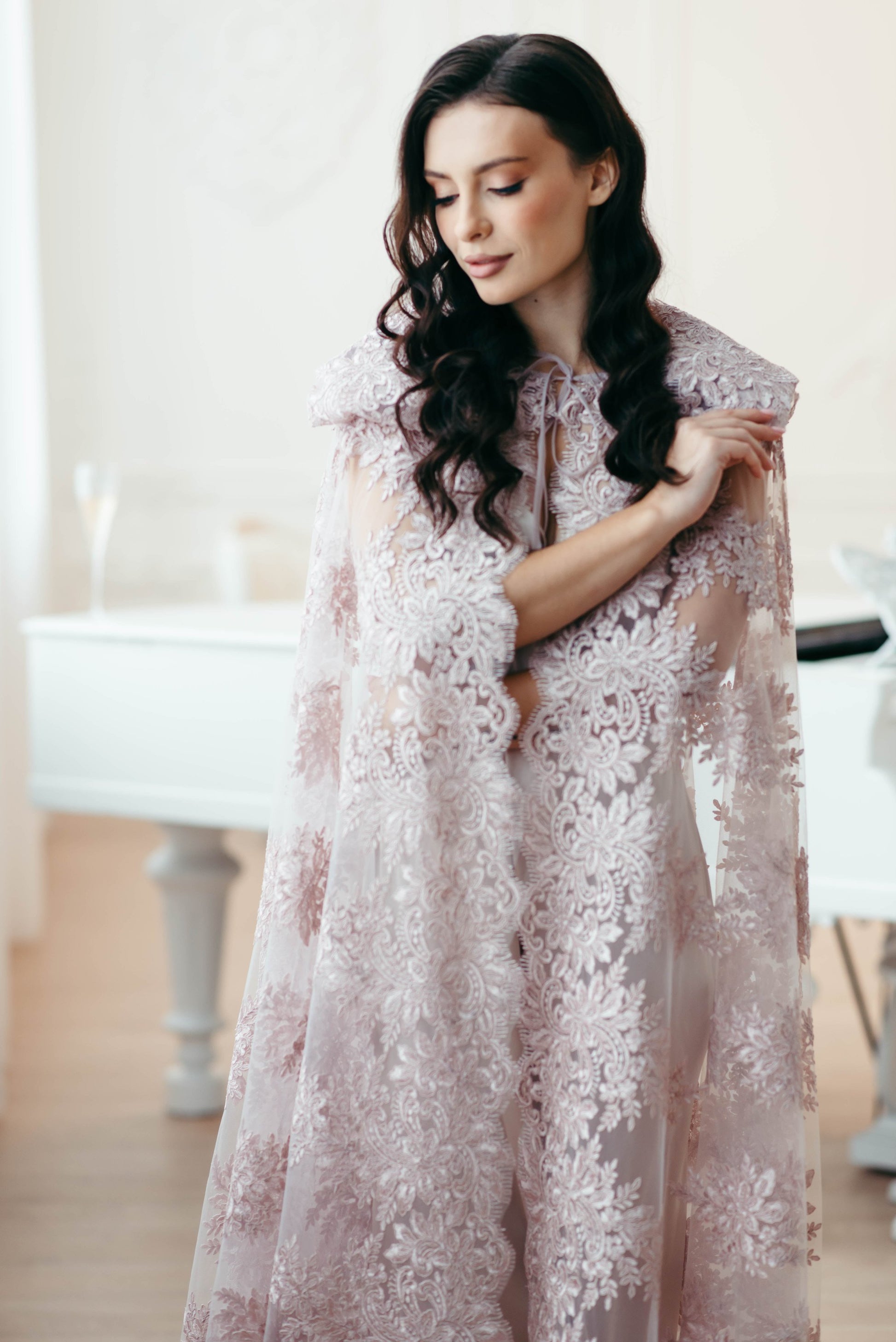 Bride in blush wedding cape with scalloped lace and hood