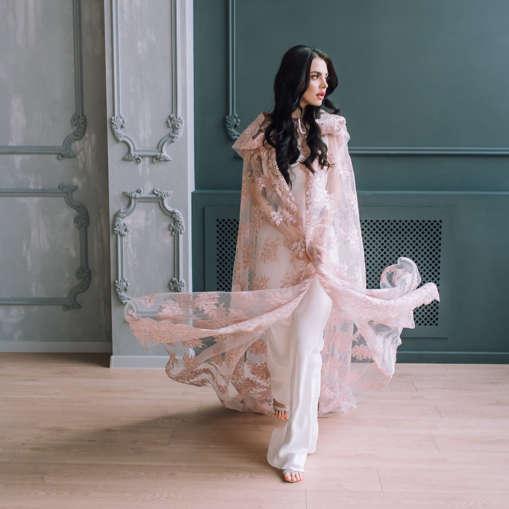 Blush lace cape in motion, worn over minimal bridal jumpsuit