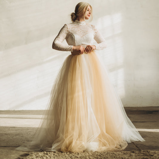 Bride wearing a long-sleeved wedding dress alternative, pairing a wedding topper with an ivory and cream bespoke maxi tulle skirt.