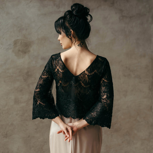 Black lace bridal top with wide sleeves styled with a blush bridal skirt, ideal for modern brides seeking a non-traditional wedding look.