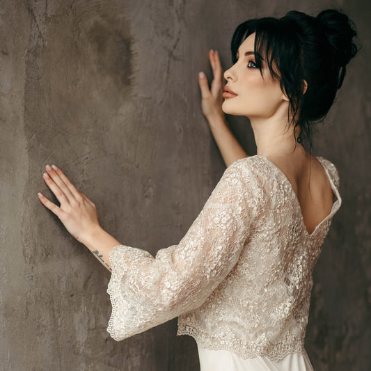 Over-the-shoulder shot of bride in blush lace crop top with deep V-back, designed for movement and rewearability.