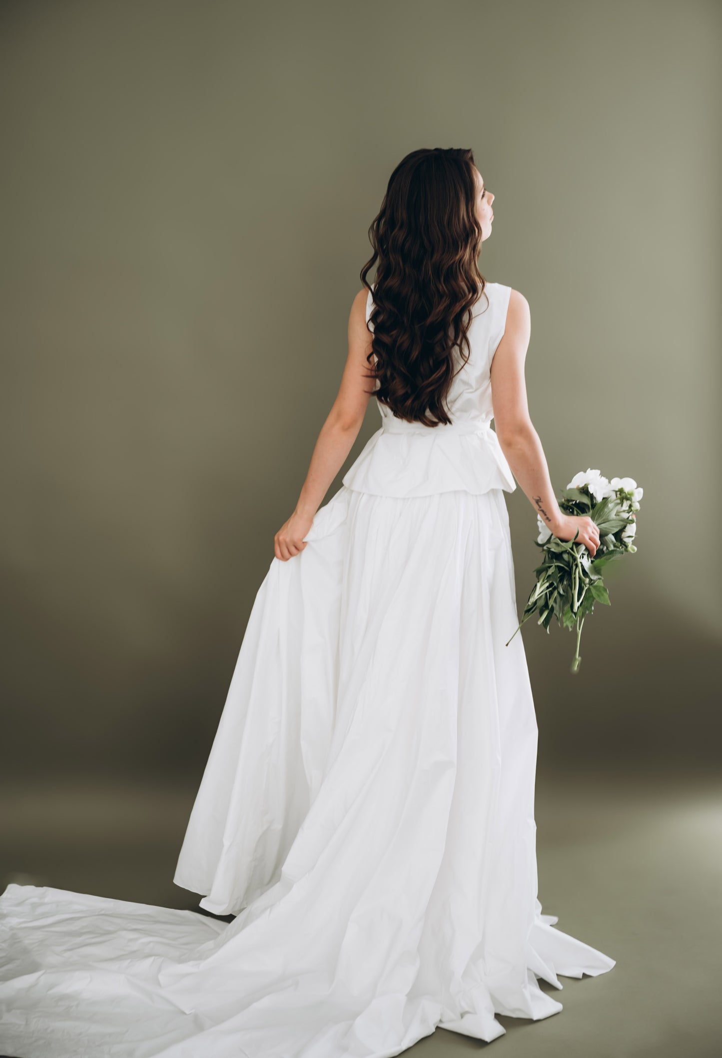 Bride in a minimalist white wedding two piece holding a wedding bouquet