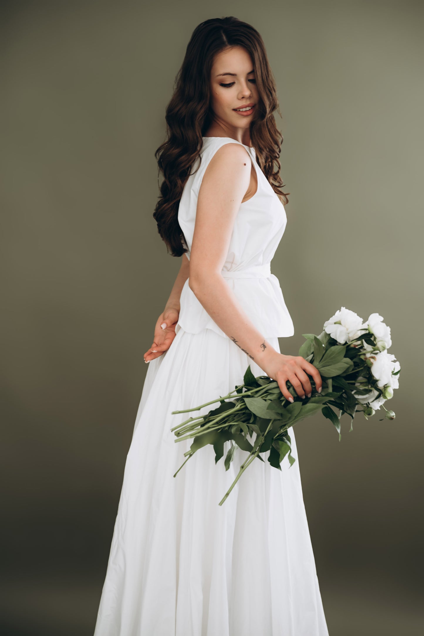 Bride wearing white taffeta skirt and sleeveless top with bouquet – two piece bridal outfit