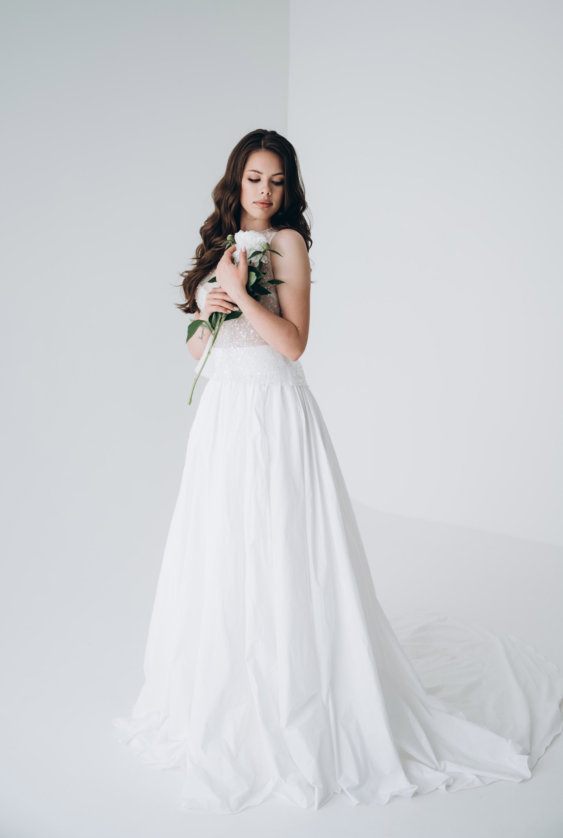 Model wearing white taffeta skirt in natural light, showcasing fluid movement