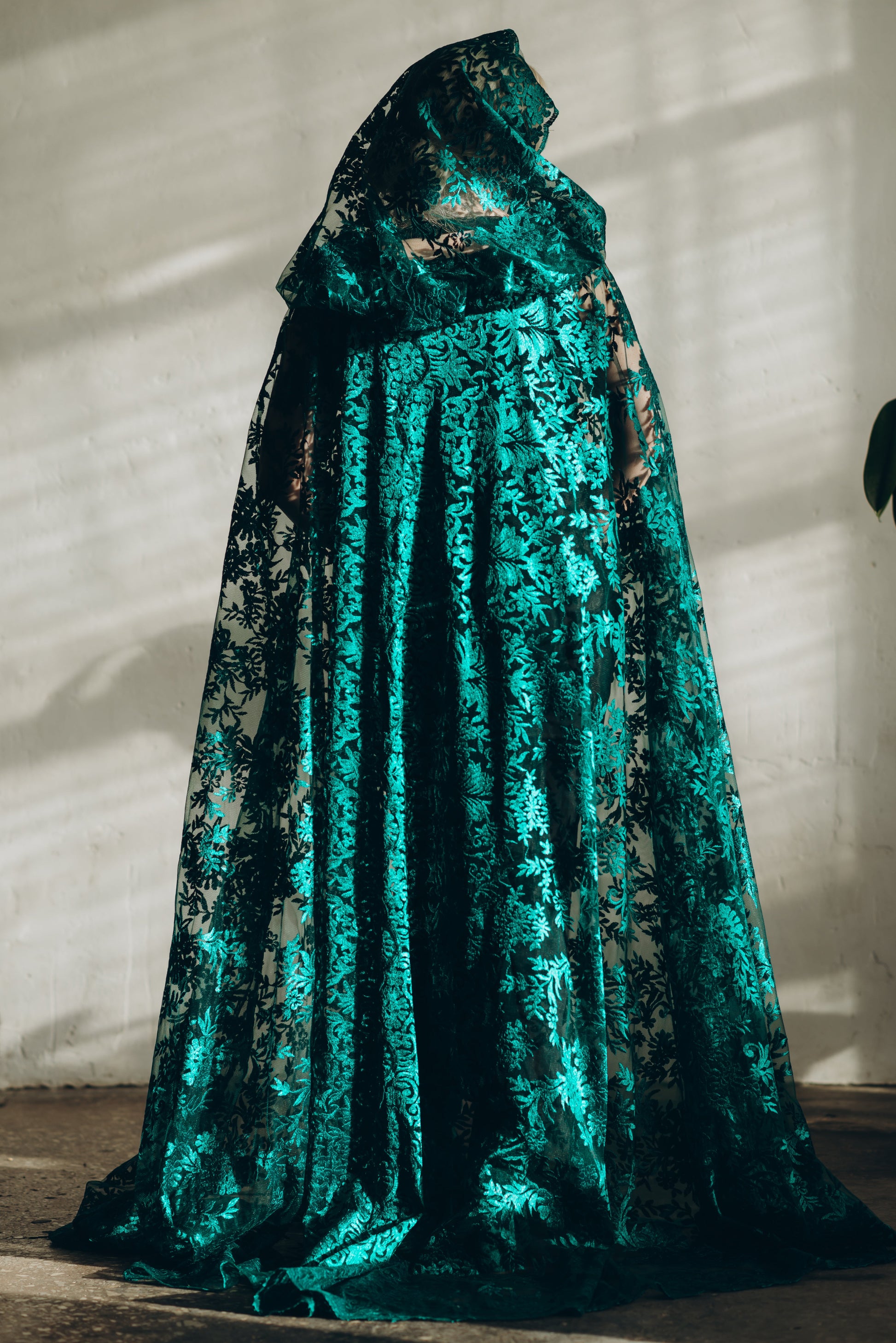 Back view of teal lace cloak with hood and full scalloped hem