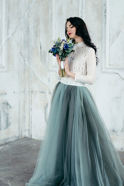 Full-length view of ivory lace wedding blouse paired with a flowing green ombré tulle skirt for a unique bridal look.