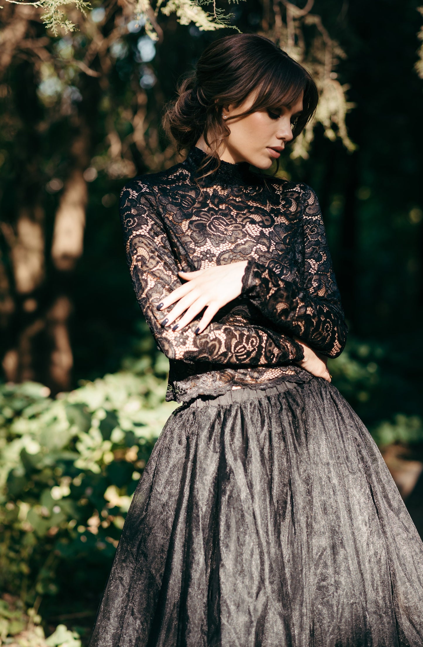 Front close-up of black lace wedding top with high neckline and sheer sleeves, paired with a full black tulle skirt for a dramatic effect.