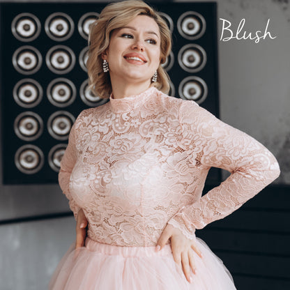  Blush pink lace top on plus-size bride, shown in a flattering close-up highlighting the romantic high neck and long sleeves.