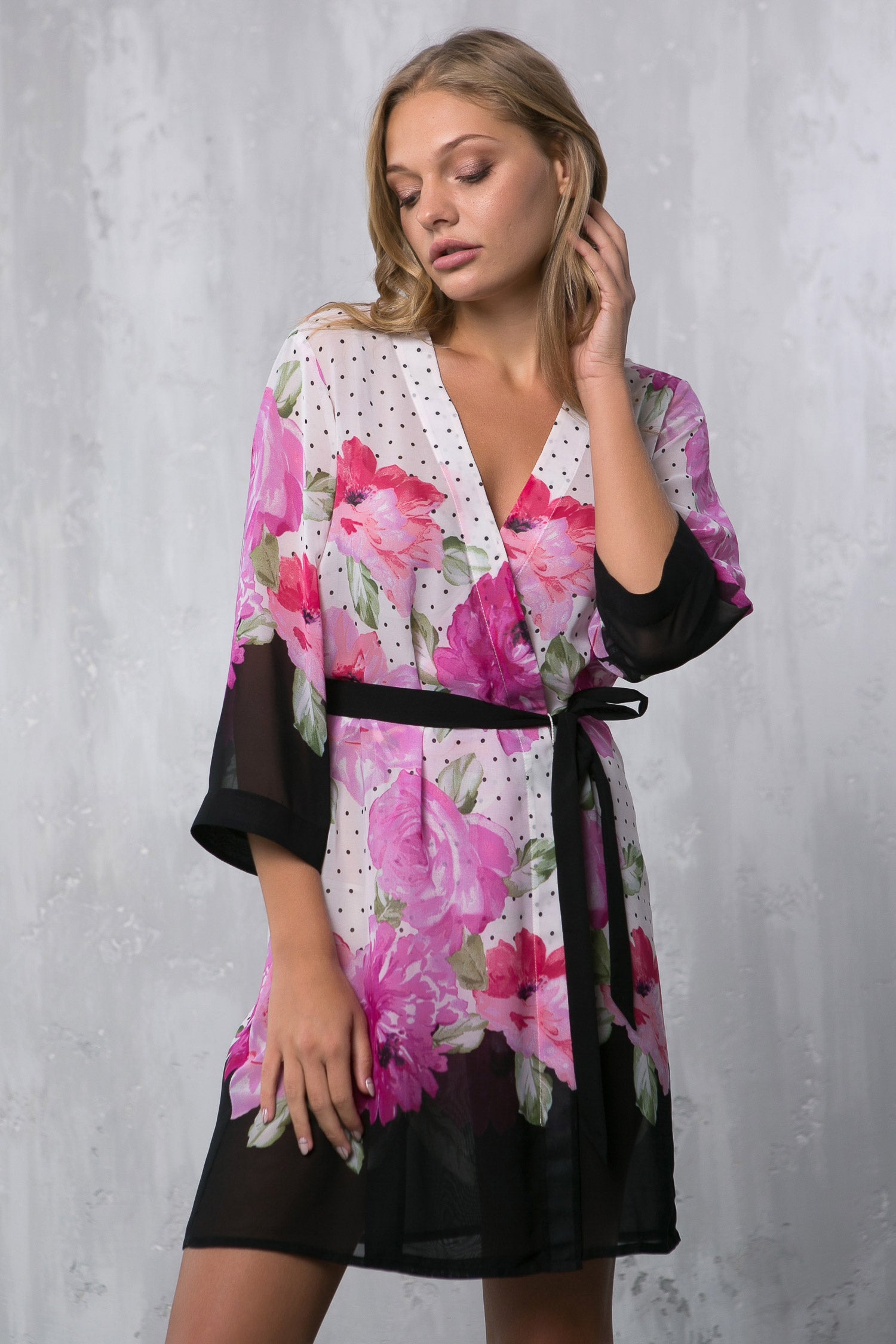 Woman wearing a floral kimono-style robe against a gray background