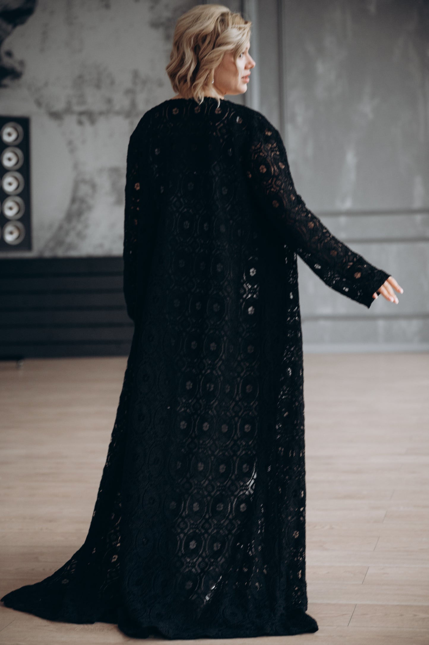 Black macramé lace bridal cape, close up with hand gesture