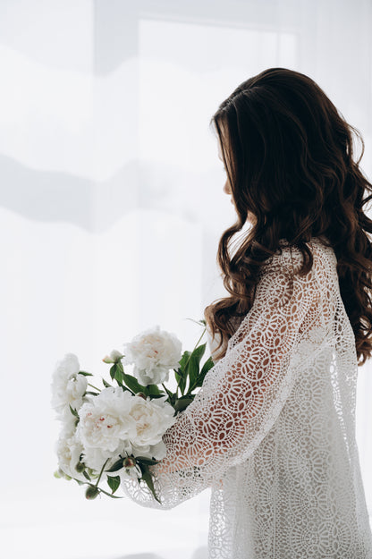 Bride wearing white wedding dress, hand to face