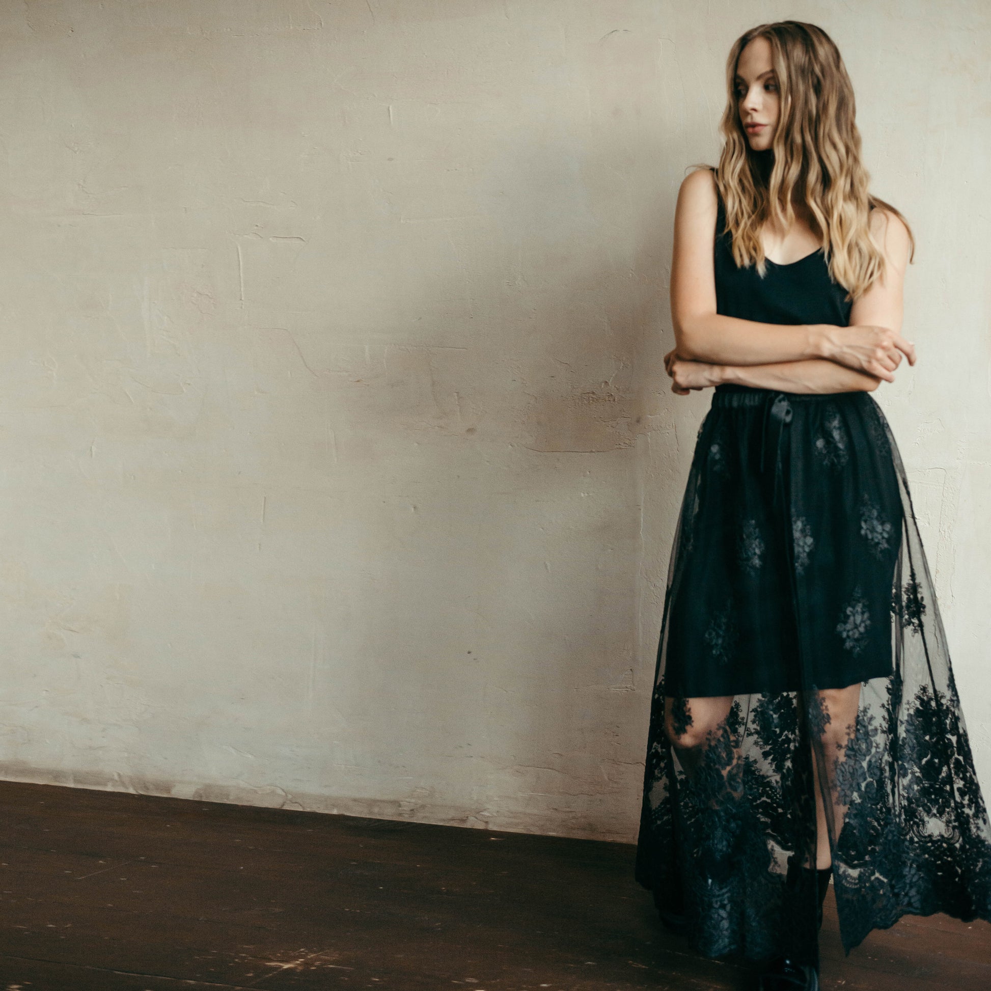 Black lace skirt styled with a mini dress for a statement festival look, combining bohemian flair with modern edge.