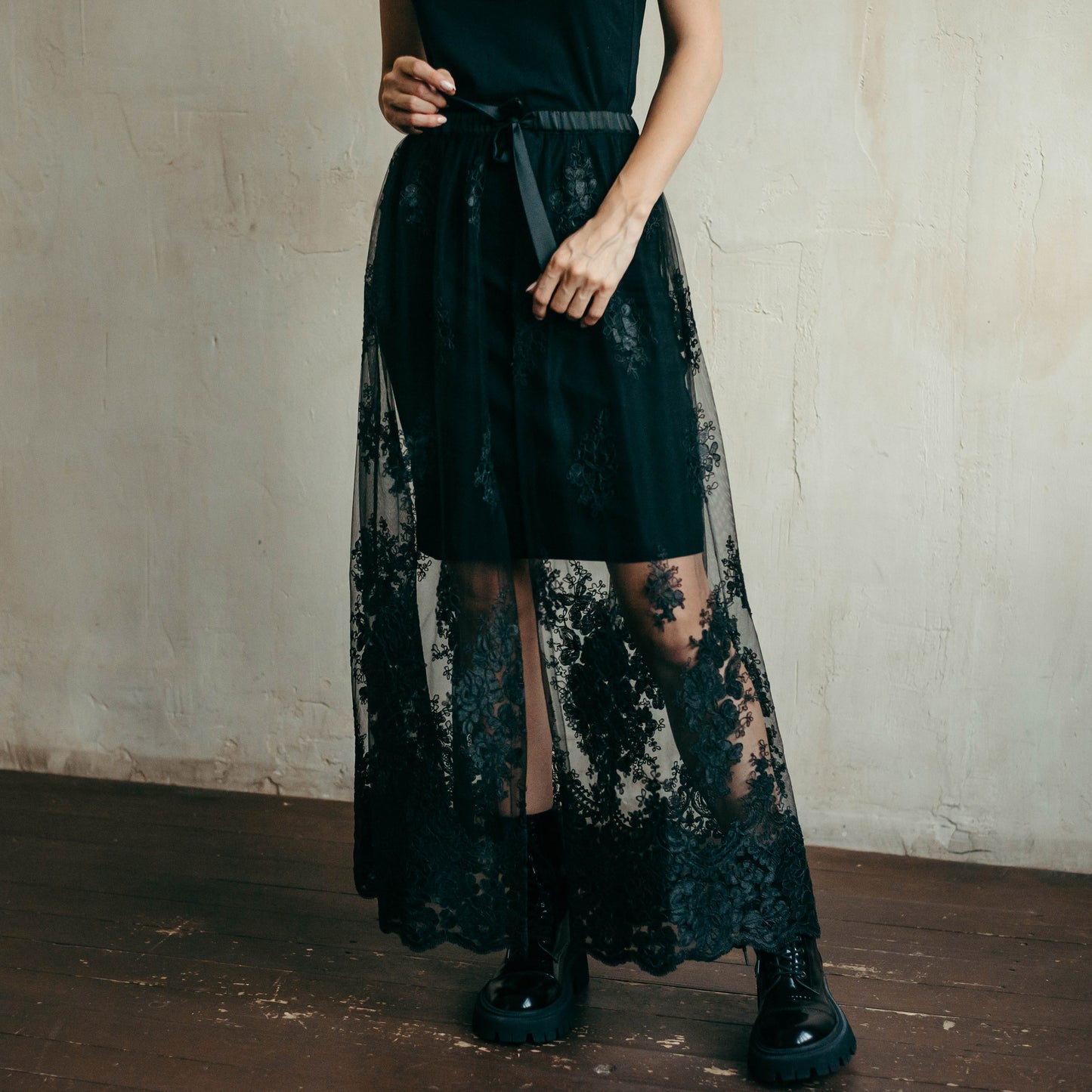 Black lace skirt paired with biker boots creating a rock-chic festival outfit or edgy bridal style for special occasions.