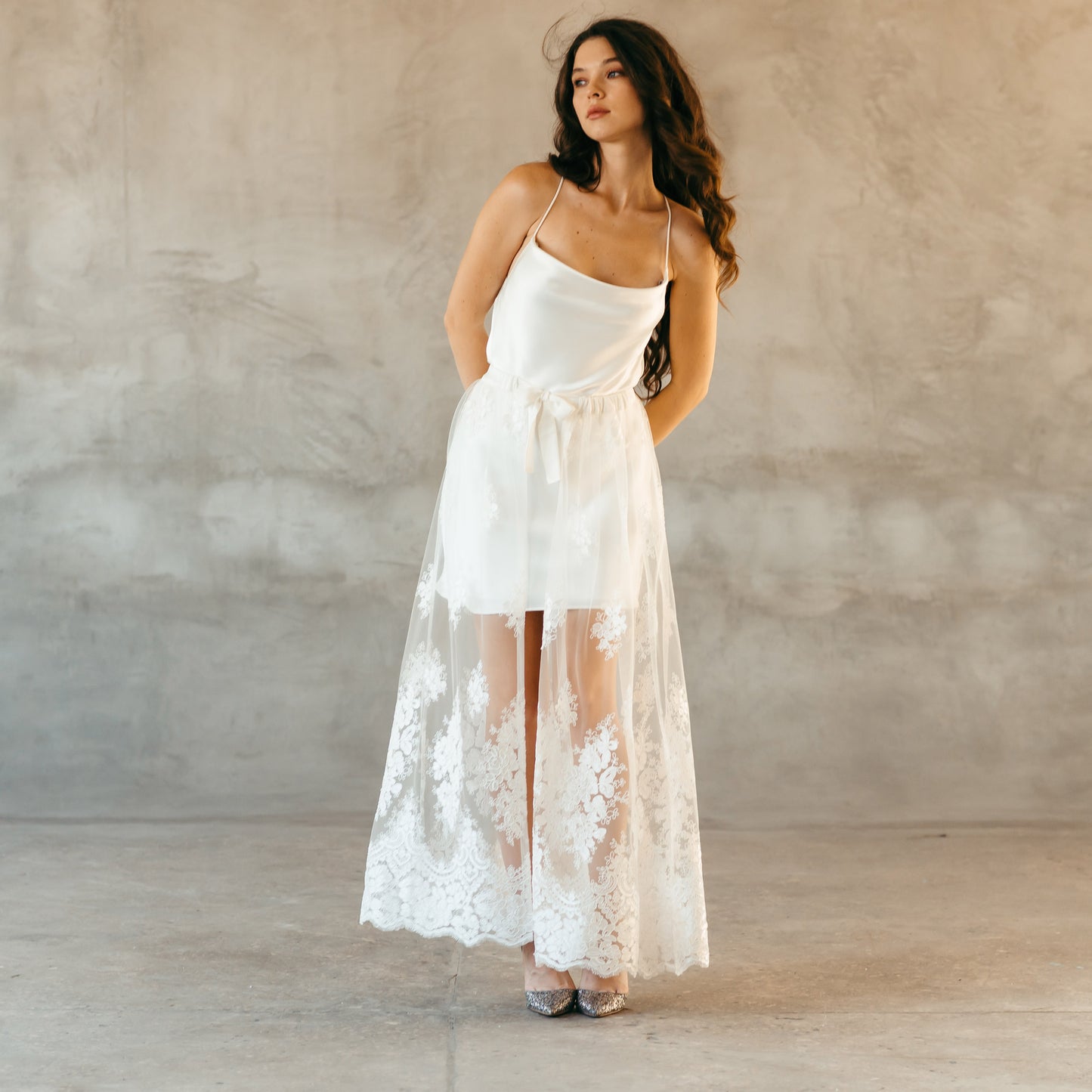 White lace skirt styled for a beach wedding showcasing its sheer, flowing elegance, perfect for alternative bridal wear or festival celebrations.