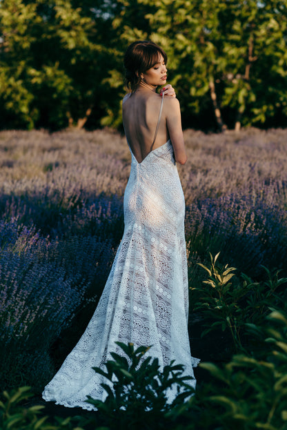 Liv macramé lace wedding dress with open back and sweeping train photographed outdoors