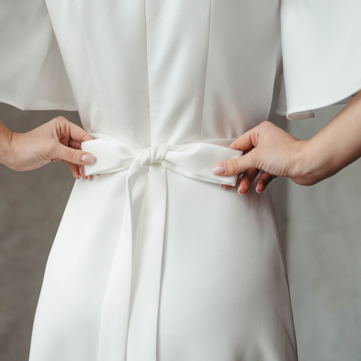 Close-up of back bow detail at waist, showcasing tie feature on dress.