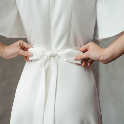 Close-up of back bow detail at waist, showcasing tie feature on dress.