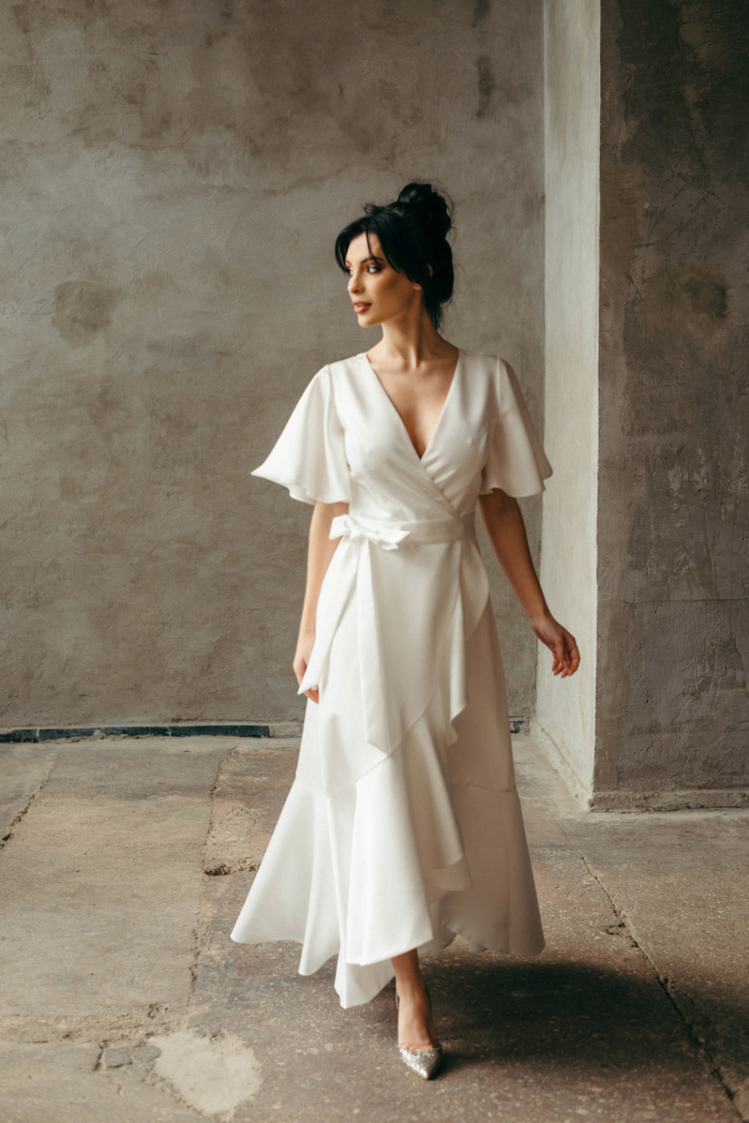 Model walking forward in ivory bridal gown, showing bohemian wedding dress in motion.