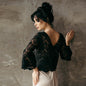 Black guipure lace wedding top with statement sleeves, styled for contemporary bridal looks or black-tie receptions.