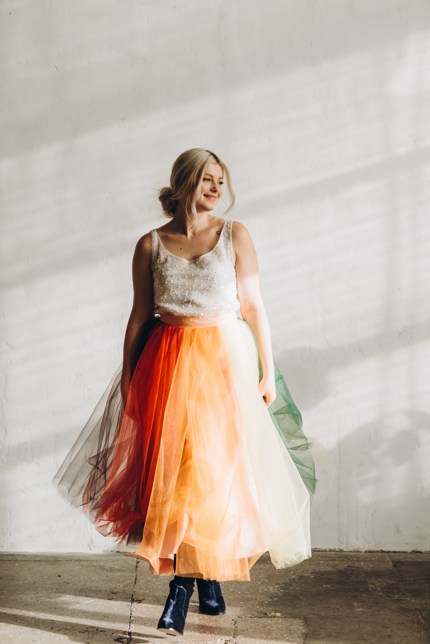 Woman wearing a sleeveless top and colorful wedding skirt as bridal separates.