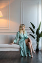 Bride in long muted green satin robe, elegant bridal loungewear for honeymoon or spa