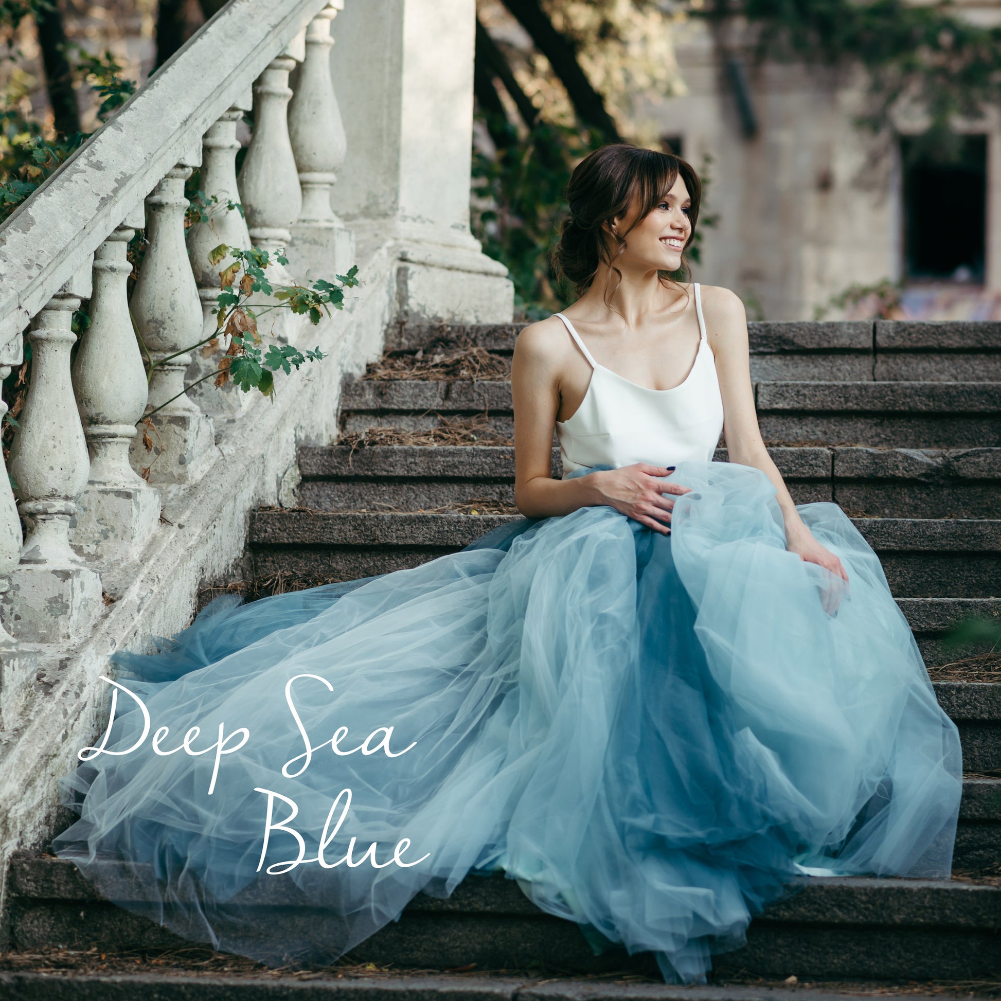 Outdoor bridal portrait in layered deep sea blue skirt and sleeveless white cami top