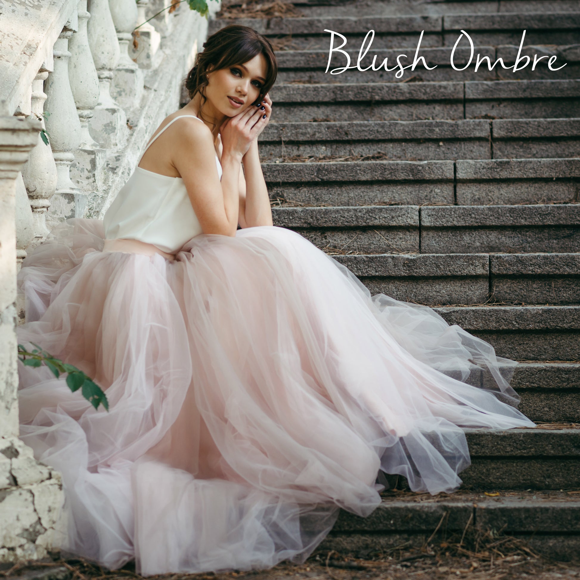 Bride on stone stairs wearing blush pink ombre bridal skirt – tulle wedding separates for alternative brides.
