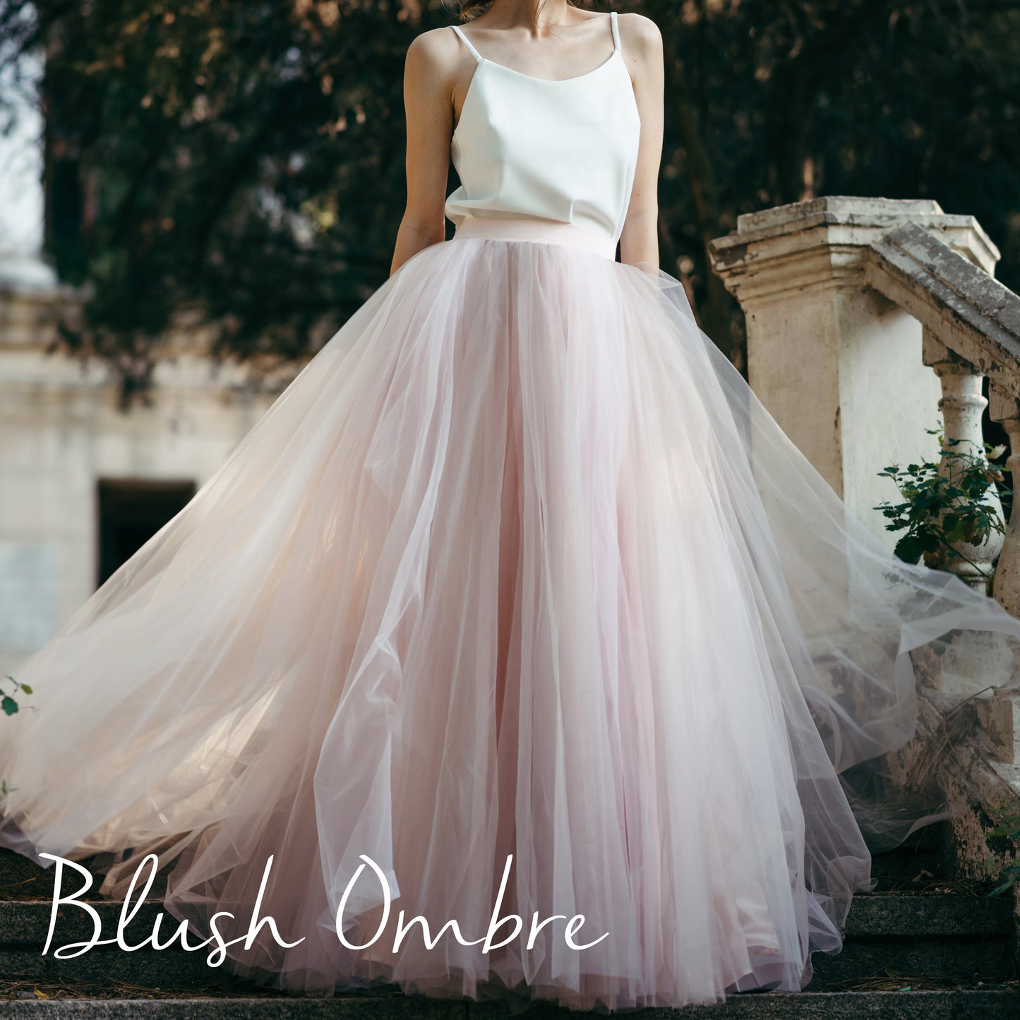 Close-up of layered blush ombré tulle wedding skirt styled with sleeveless bodice