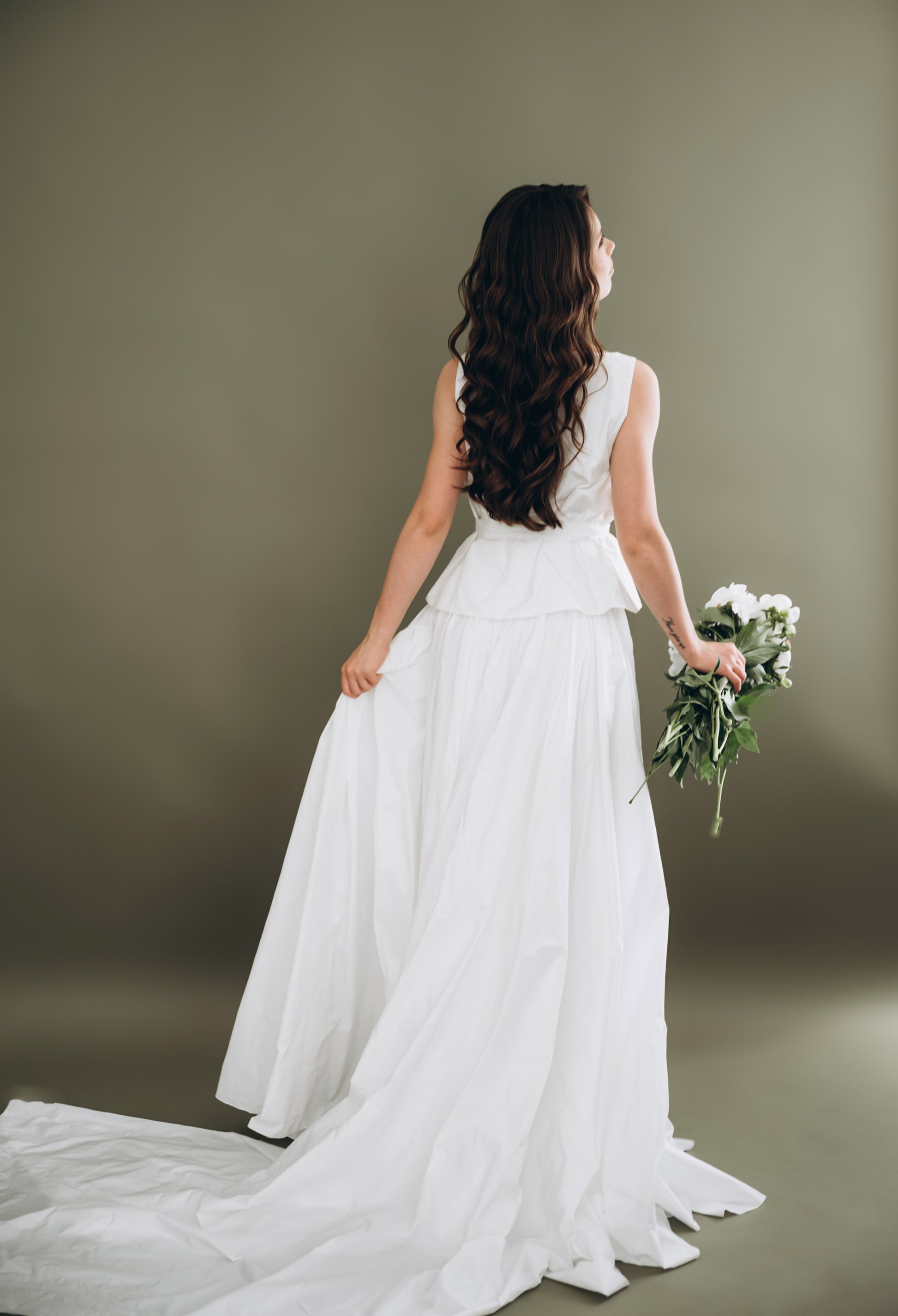 Bride in a minimalist white wedding two piece holding a wedding bouquet 