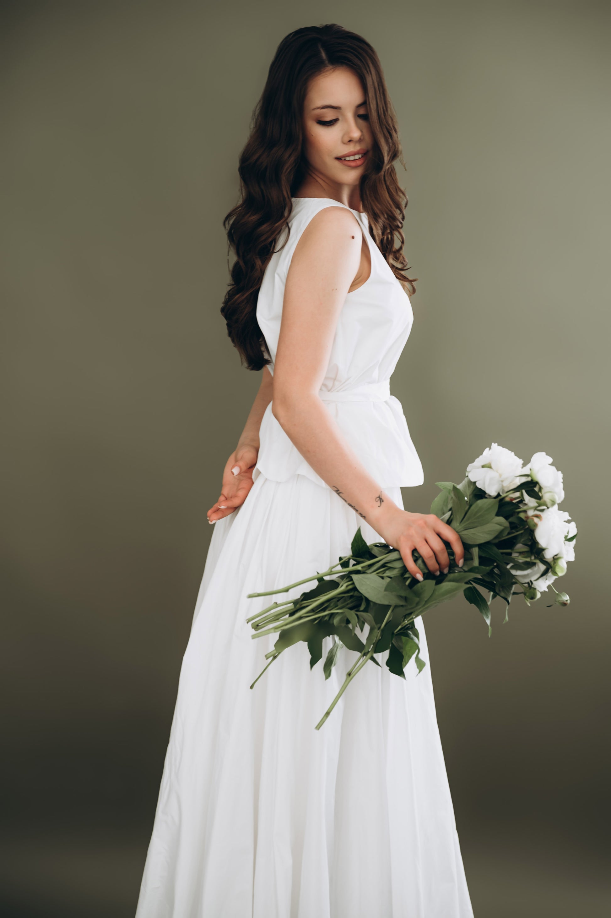 Bride wearing white taffeta skirt and sleeveless top with bouquet – two piece bridal outfit