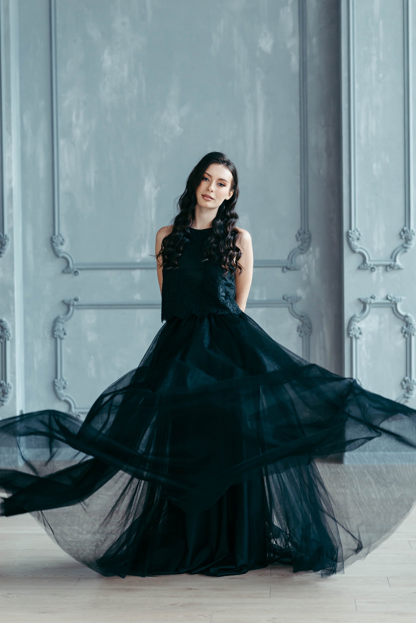 Bride wearing black tulle skirt and lace top, three-quarter back view