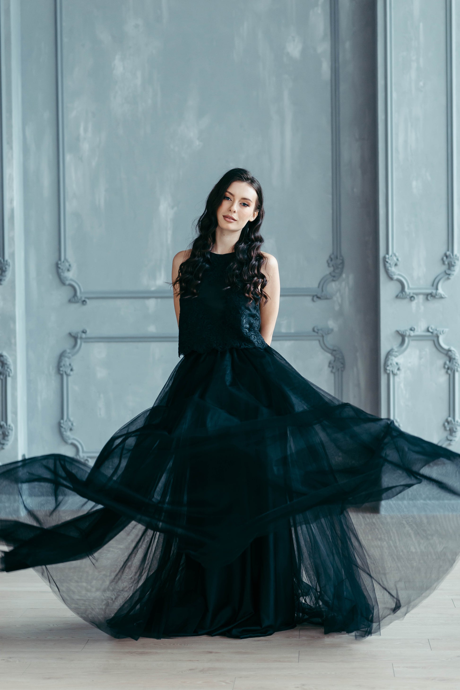 Bride wearing black tulle skirt and lace top, three-quarter back view