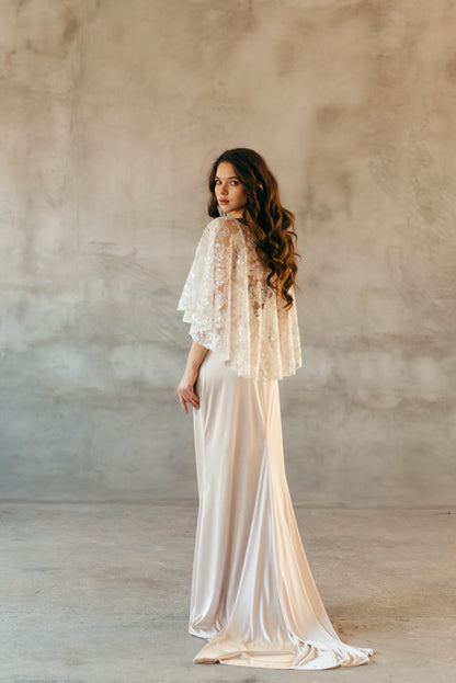 Bride wearing beaded sequined capelet, full length front view