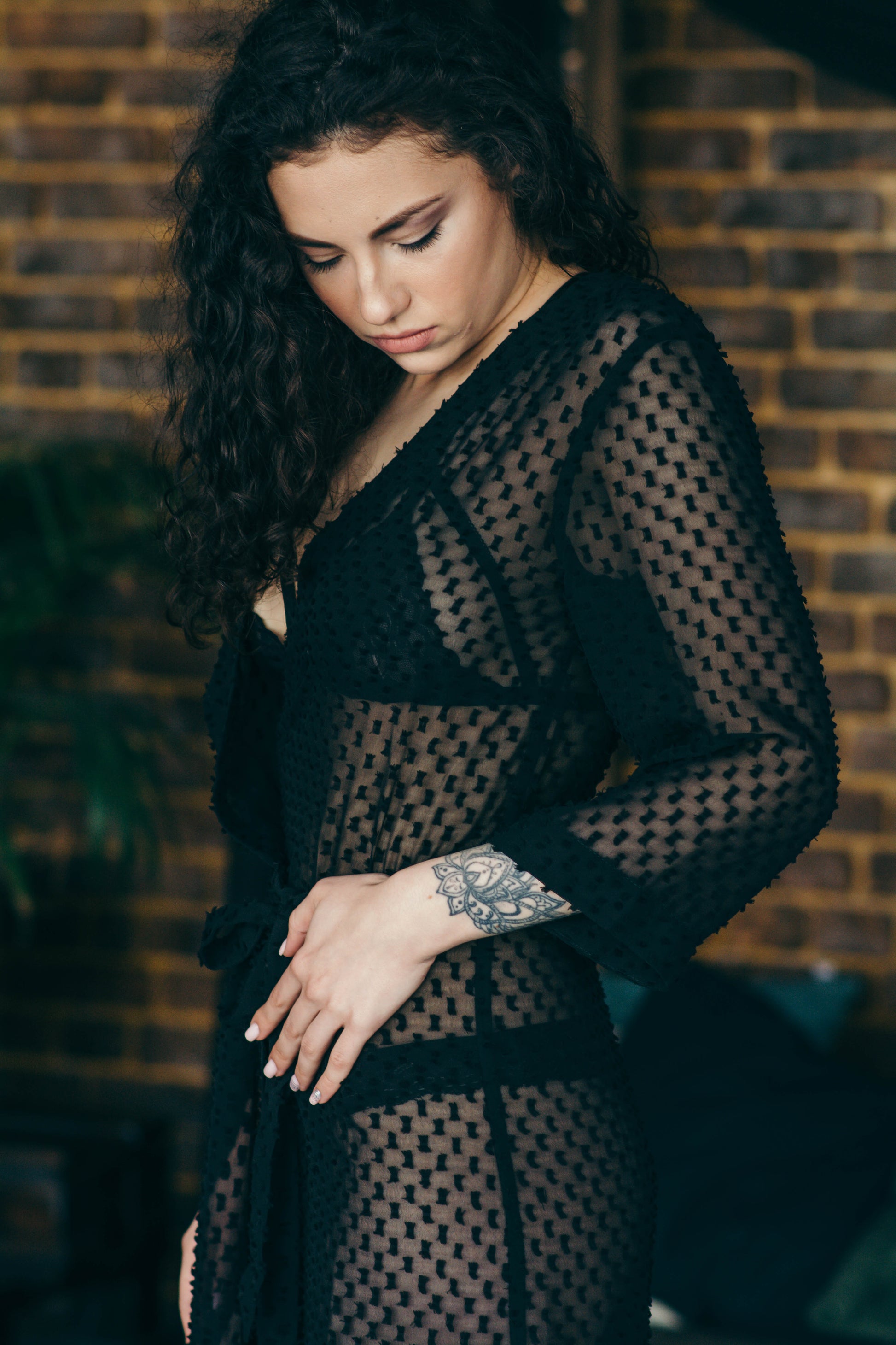 Black sheer polka dot robe, close up against brick wall
