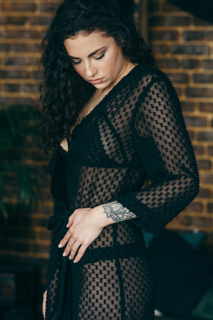 Black sheer polka dot robe, close up against brick wall